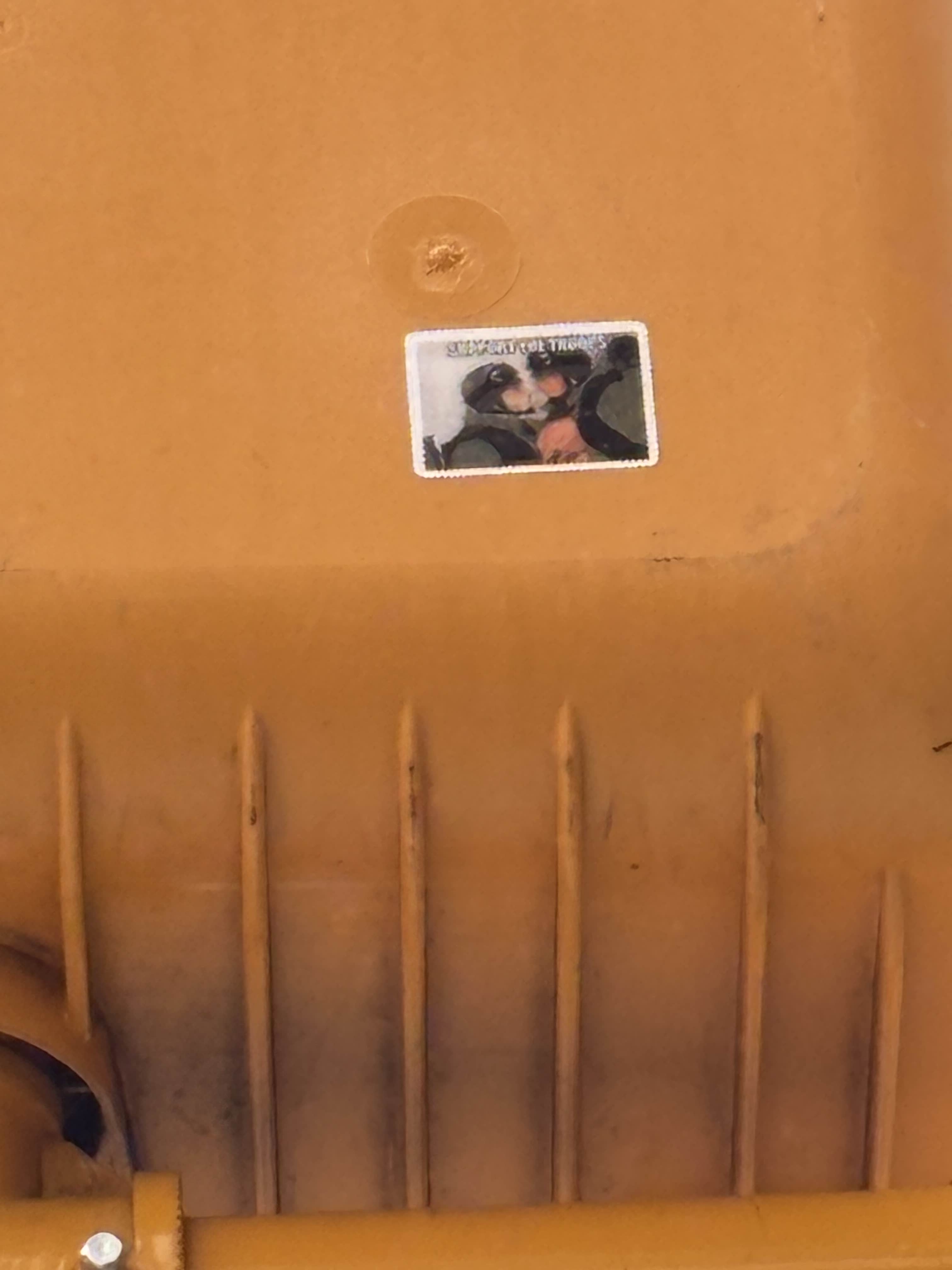 a sticker which says support the troops and features two soldiers staring at each other on a traffic light.