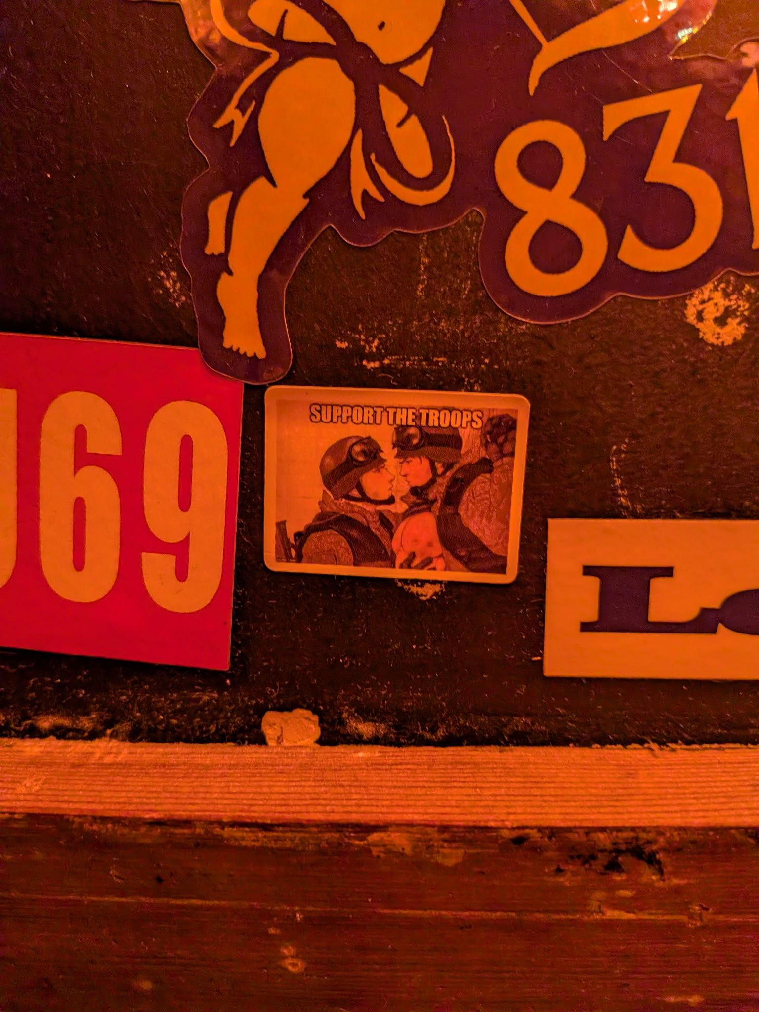 a sticker which says support the troops and features two soldiers staring at each other on the now closed restaurant Mekelburgs